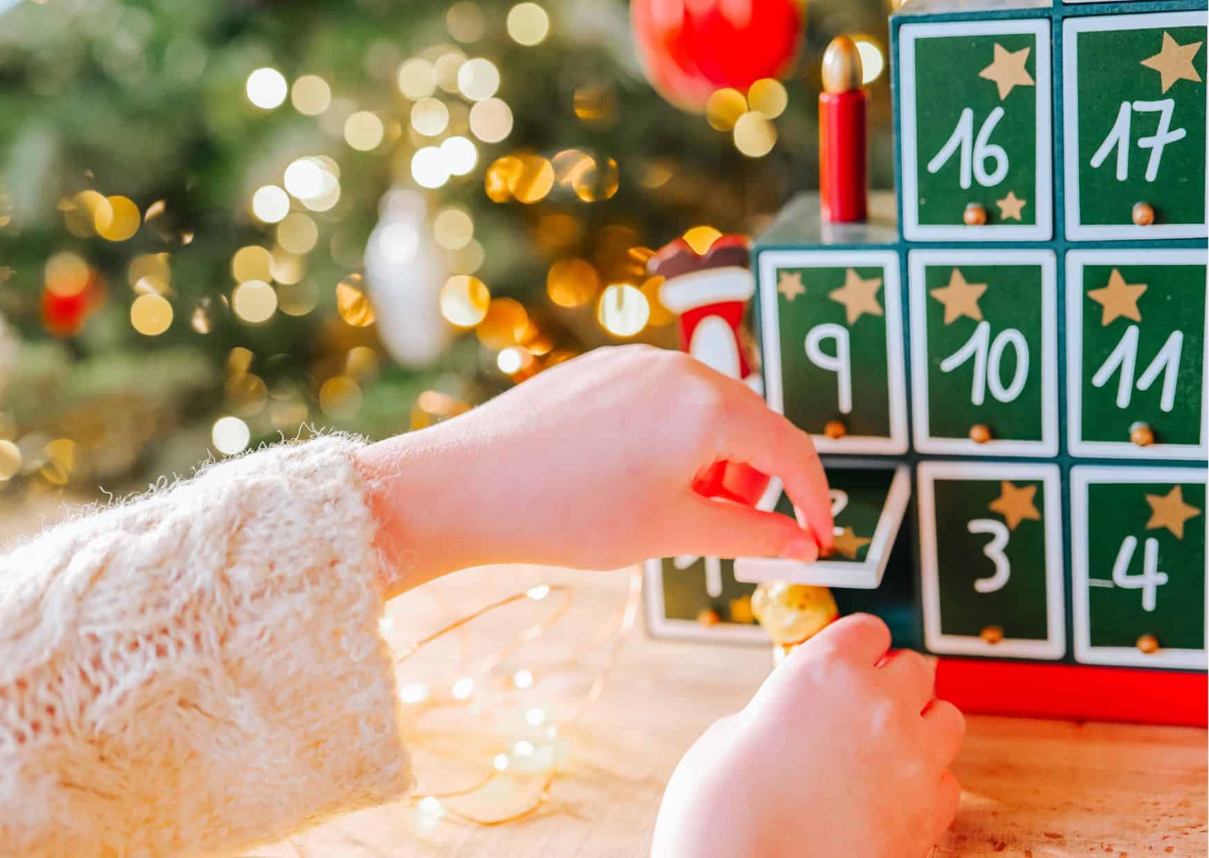 Adventskalender Anmeldeseite Adventrskalender 2025 - Ein Kind öffnet ein Türchen seines Kalenders