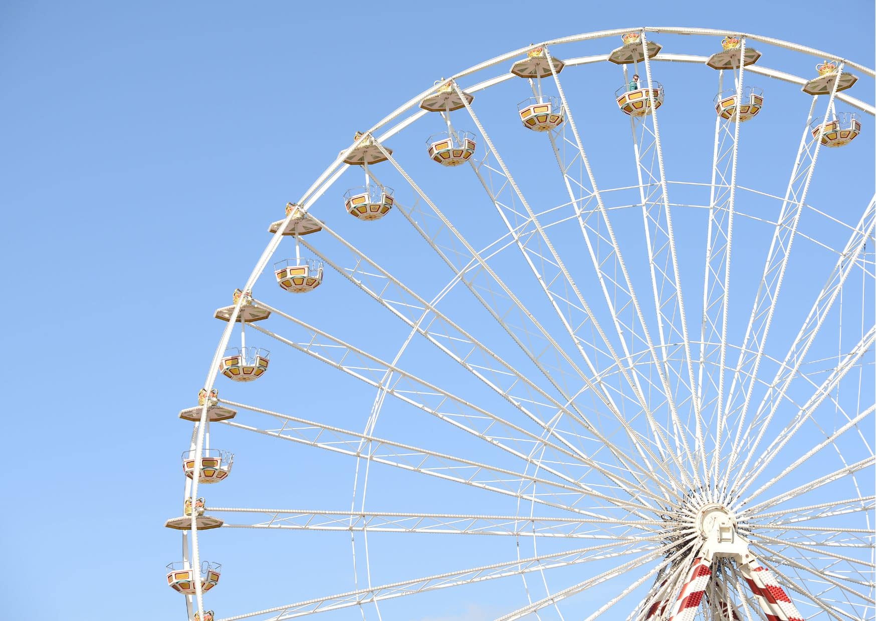 Es ist ein Riesenrad vor strahlend blauem Himmel zu sehen.